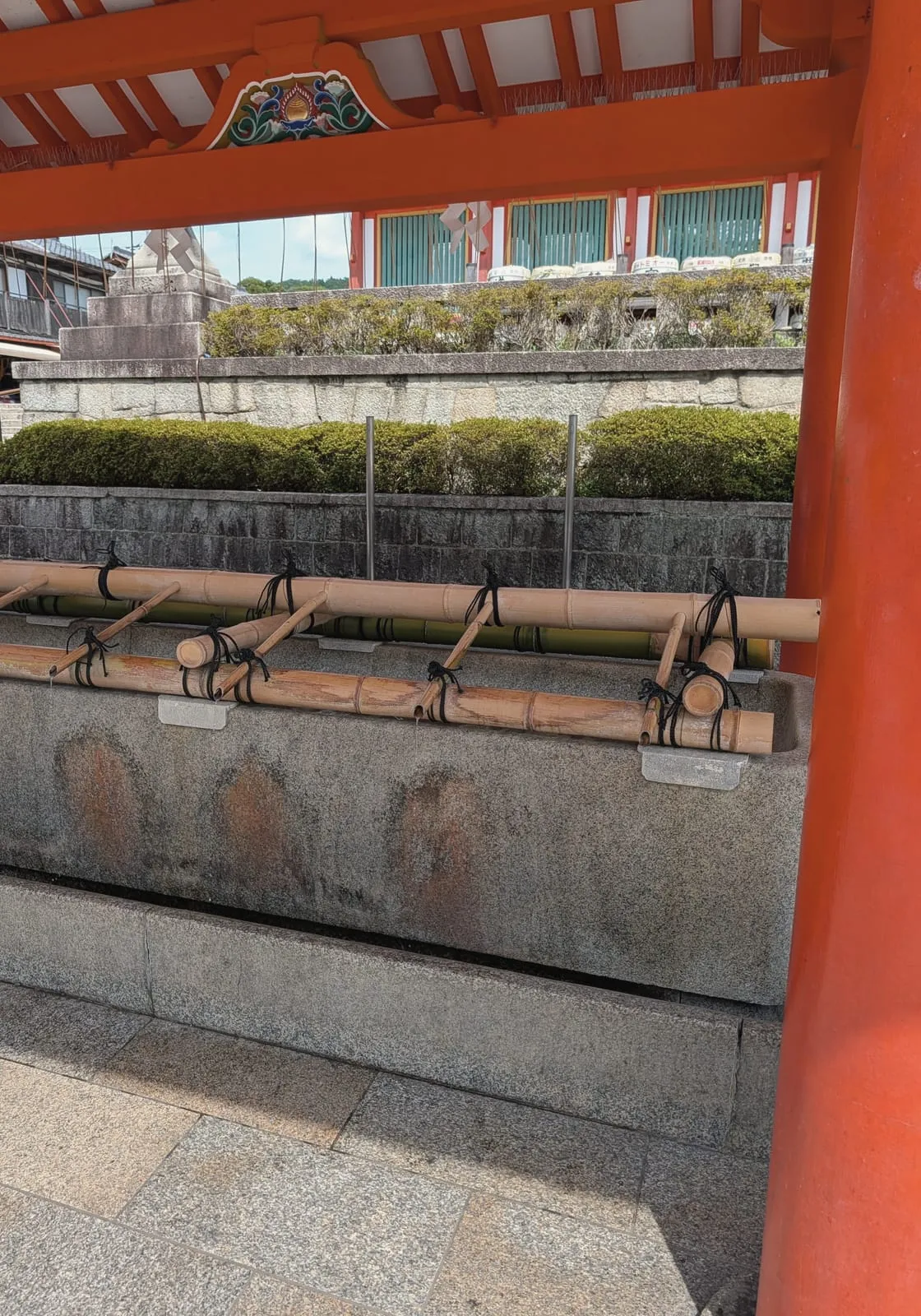 Bamboo water spouts and ladles at the purification basin at Fushimi Inari, August 22, 2026